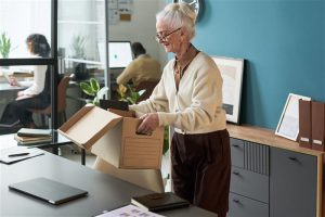 senior-caucasian-woman-packing-belongings-in-offic-